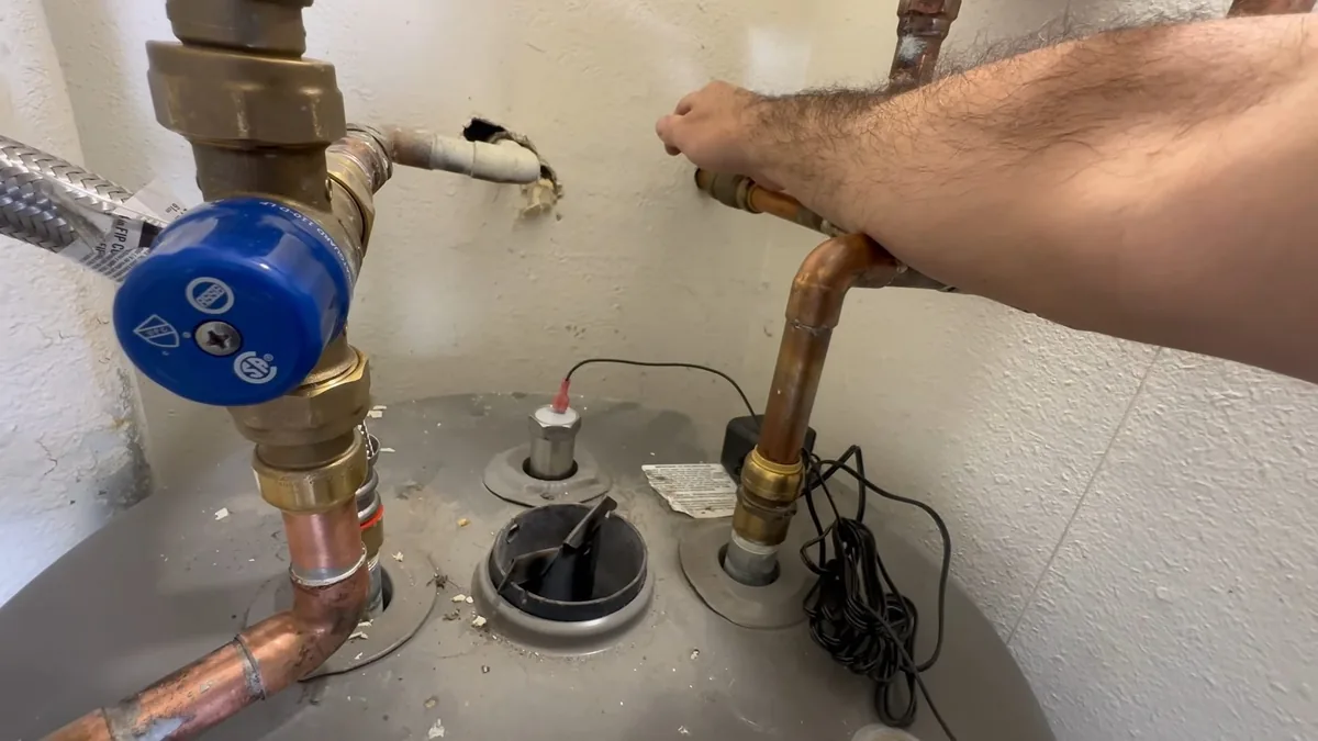 Water heater anode rod and tank connection showing mineral wear for Water Heater Lifespan in Hard-Water Homes in Fountain Valley